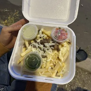 a person holding a container of food