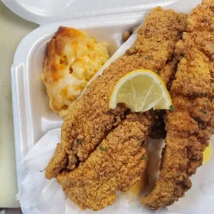 a close up of a fried chicken with macaroni and cheese