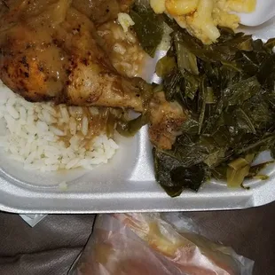 Baked chicken over rice with brown gravy and macaroni and cheese and collard greens