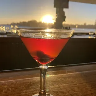 a red cocktail in a coupe glass