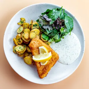 Backfish: Bier battered pollock served with remoulade sauce, pan-seared potatoes, marinated greens, and lemon.