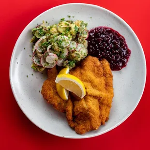 Schnitzel: tenderized breaded veal or pork cutlet served with lingonberry and a choice of potato salad or seared potatoes.