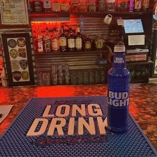 a blue bottle of bud light on a blue mat