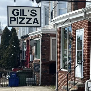 a brick building with a sign that says gil's pizza
