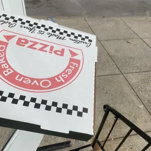 a pizza box on the sidewalk