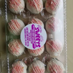 a clear plastic container with white and pink frosting