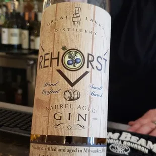 a person holding a bottle of gin rickey