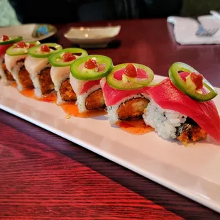 a long rectangular plate with a variety of sushi