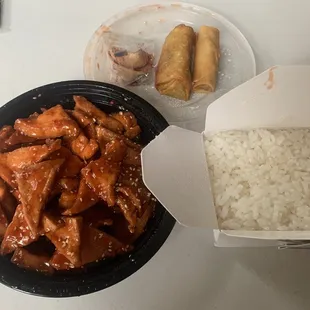 Sesame tofu with rice and two egg rolls.