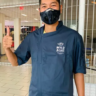 a man wearing a mask and giving a thumbs up