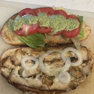 a close up of a sandwich with onions and tomatoes