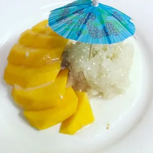 a plate of rice, mangoes, and an umbrella