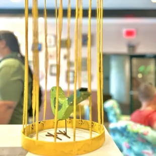 a yellow bird in a cage