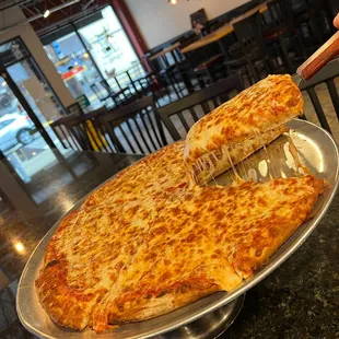 a pizza being cut by a pizza cutter