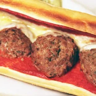 a meatball sandwich with tomato sauce and cheese