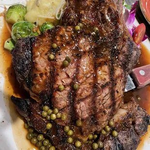 a steak with peas and potatoes