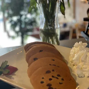 a plate of chocolate chip cookies and whipped cream