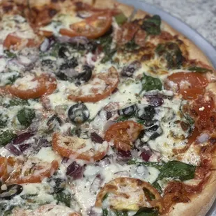 a pizza with tomatoes and spinach