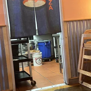 Meat sitting uncovered near the floor, near a trash can. Yum!!