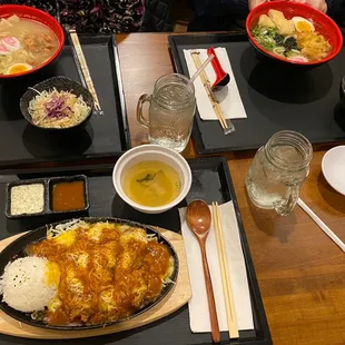 a table with bowls of ramen, rice, and a bowl of soup