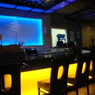 Sushi bar, register, and kitchen entry.