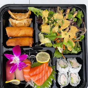 Bento box with sashimi and California rolls