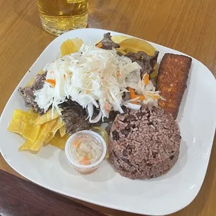 Tajadas de plátano con carne con su repollo como ensalada y arroz negrito