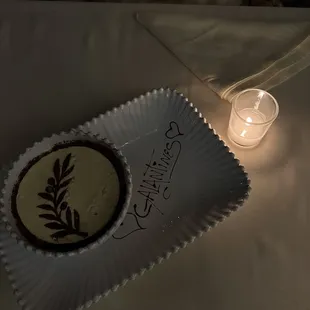 a birthday cake on a plate with a lit candle