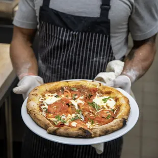 a man holding a pizza