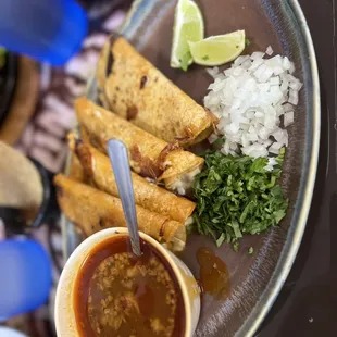 a plate of tacos and a bowl of salsa