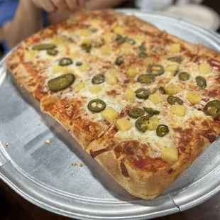a pizza with pineapple and jalapenos