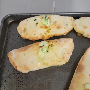 four pieces of pizza on a baking sheet