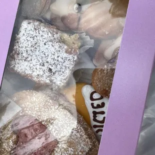 a hand holding a box of donuts