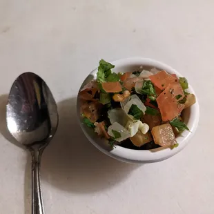 a bowl of vegetables and a spoon