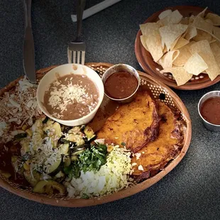Custom entree with quesabirria tacos (2) and a beef enchilada (1). 2 sides = calabacitas and refried beans. $17.95 (1/2025)