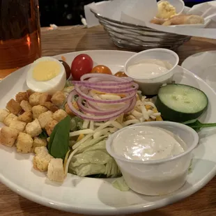 House salad with blue cheese dressing and a variety of tomatoes. Note the soft rolls in the background