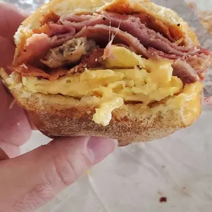 Sausage, Ham, Bacon egg and cheese Salt pepper Ketchup on a hero.