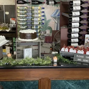 a counter with cakes and wine bottles