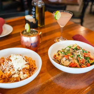 two bowls of pasta and a cocktail