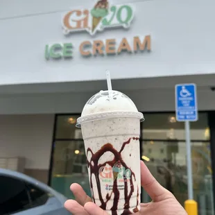 a hand holding a cup of ice cream