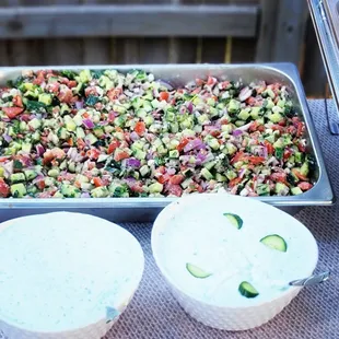 a tray of salad and a bowl of dip