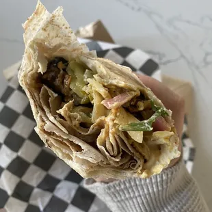 a hand holding a burrito