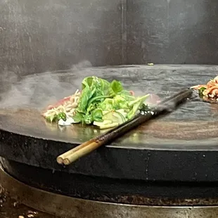 a pizza being cooked on a grill