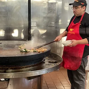 a man cooking food on a grill