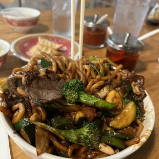 a bowl of noodles with beef and broccoli
