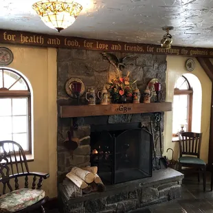 a stone fireplace and chairs