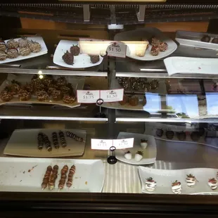 a variety of desserts in a display case