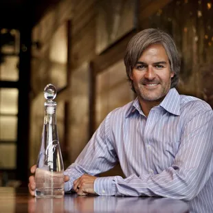 a man sitting at a table with a bottle