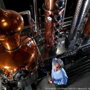 a woman standing in front of copper stills