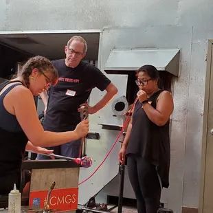 Blowing into the glass while the instructor shapes the glass